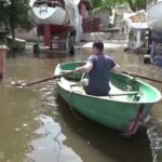 Un bărbat „traversează drumul” într-o barcă după spargerea unui baraj din Ucraina