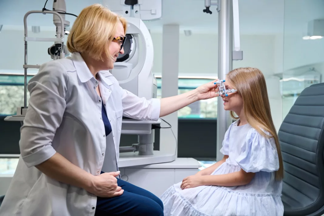 Oculist examining axis and strength of child's astigmatism