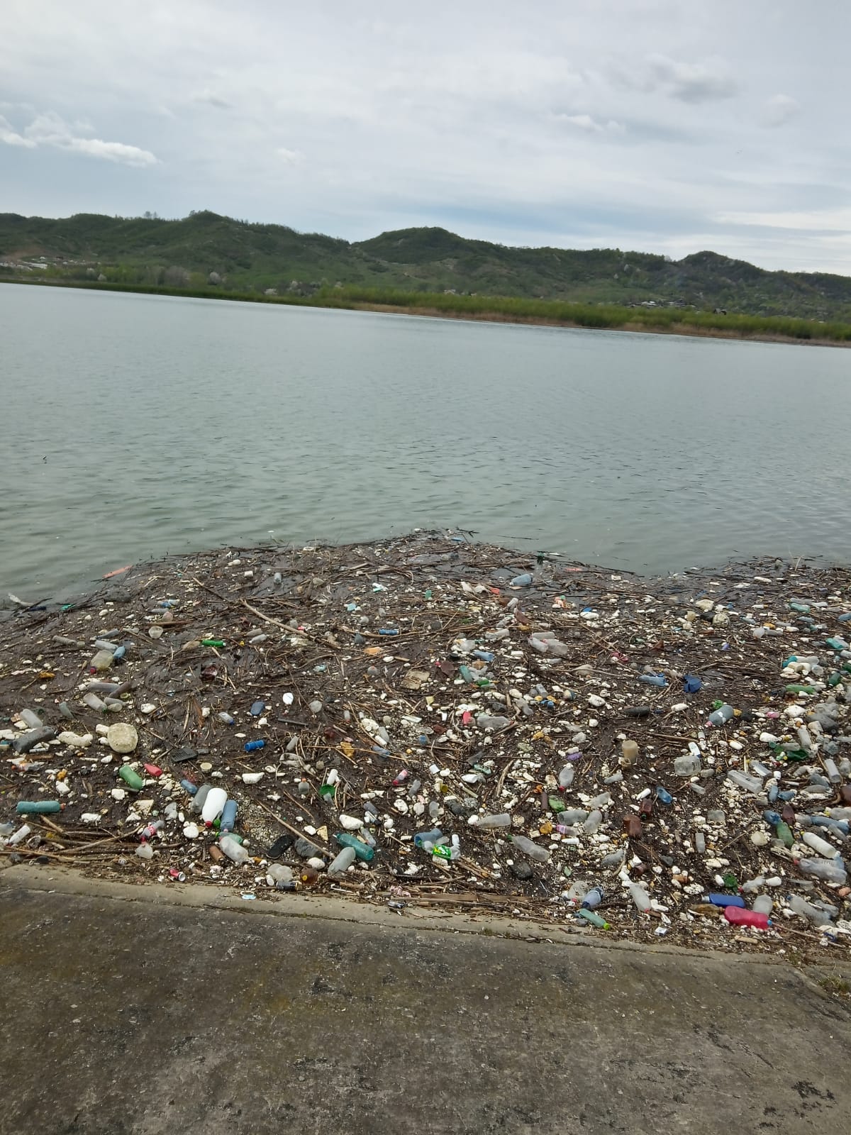 Grămezi de gunoaie pe suprafața apei barajului din stațiunea Pucioasa. FOTO și VIDEO