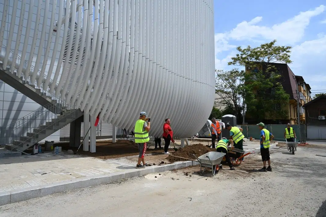 Muncitori construind exteriorul unei clădiri moderne