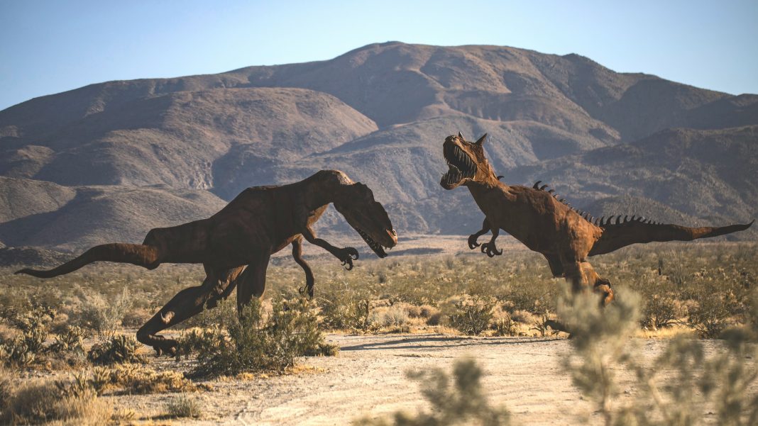 Dinozauri metalici alergând în peisaj desertic / dinozaur fosilă