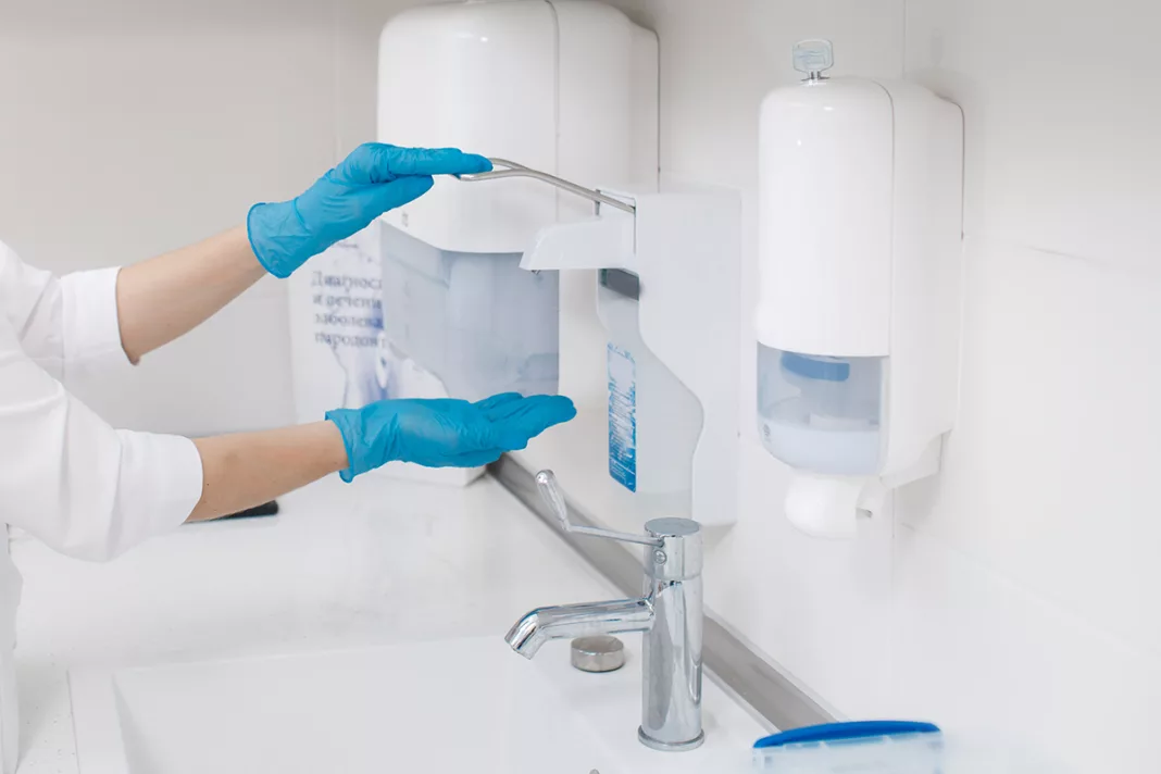Medic schimbând dispenserul de dezinfectant în laborator