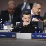 Zelensky reflectând la o conferință internațională