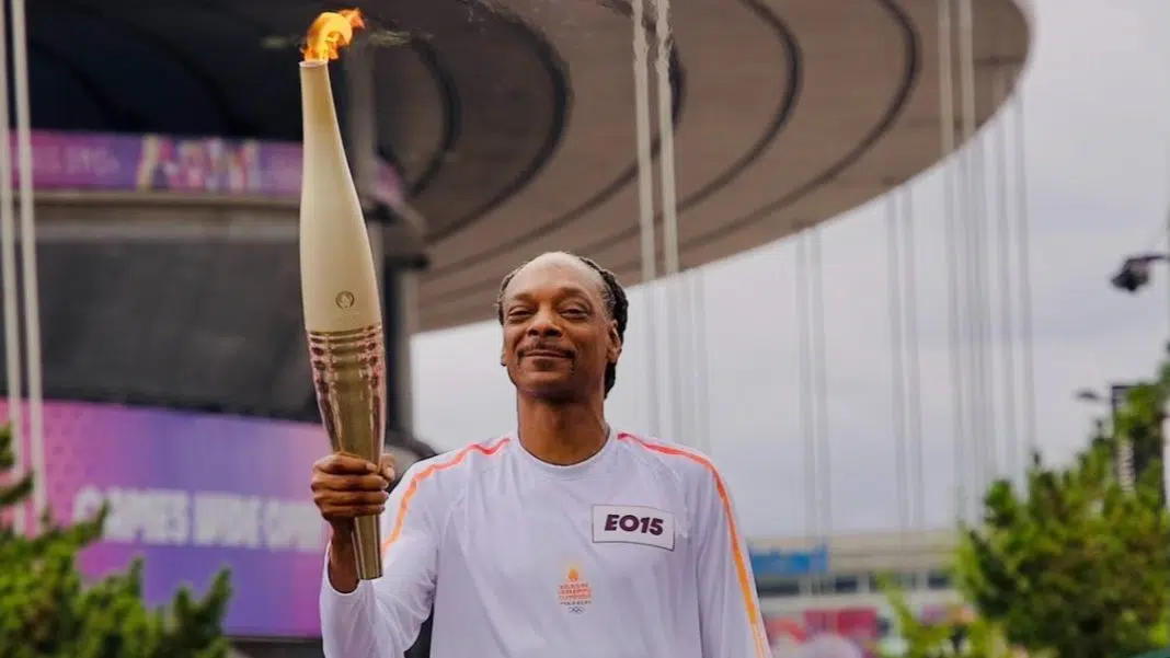 Bărbat zâmbind cu torța olimpică / snoop dog jo 2024