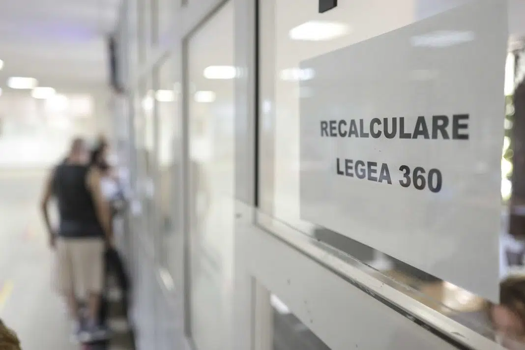 Semn 'Recalculare Legea 360' cu persoane în fundal