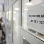 Semn 'Recalculare Legea 360' cu persoane în fundal