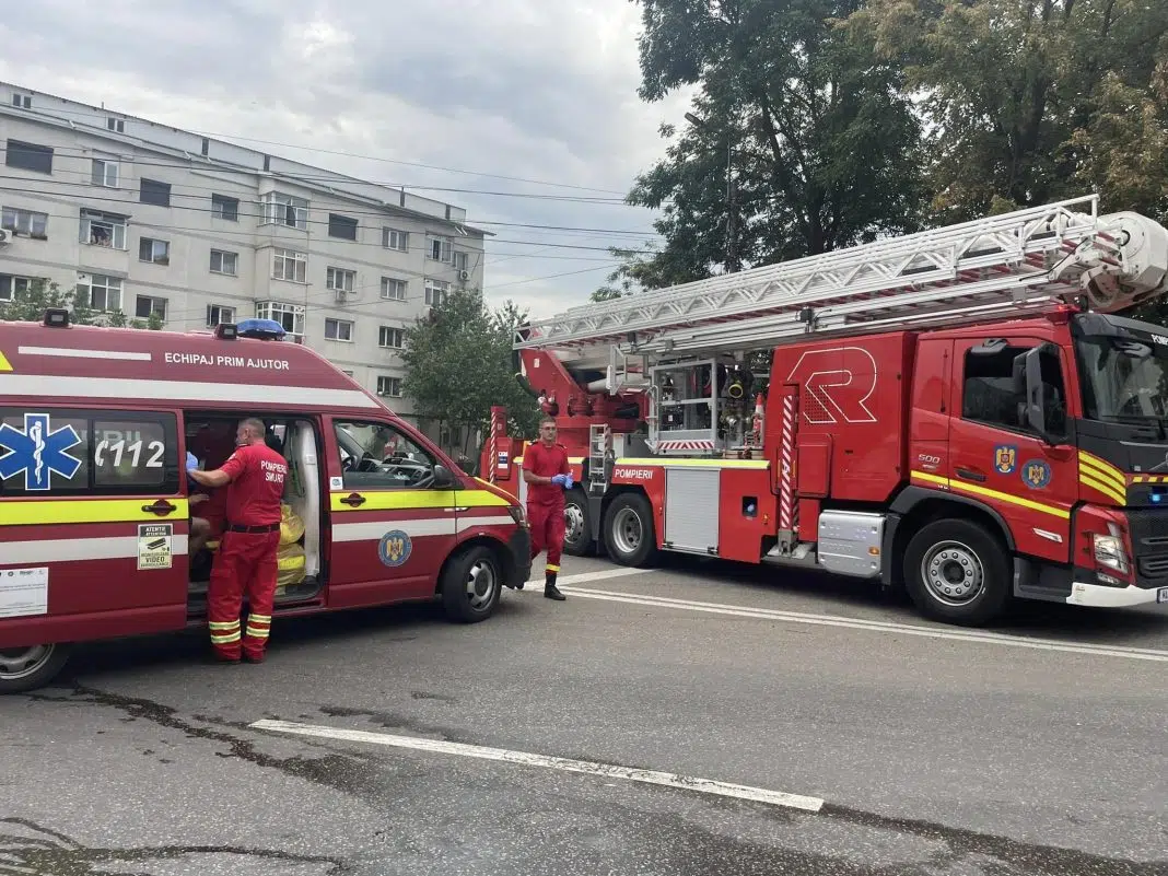 Pompieri și ambulanță intervenind în fața unui bloc