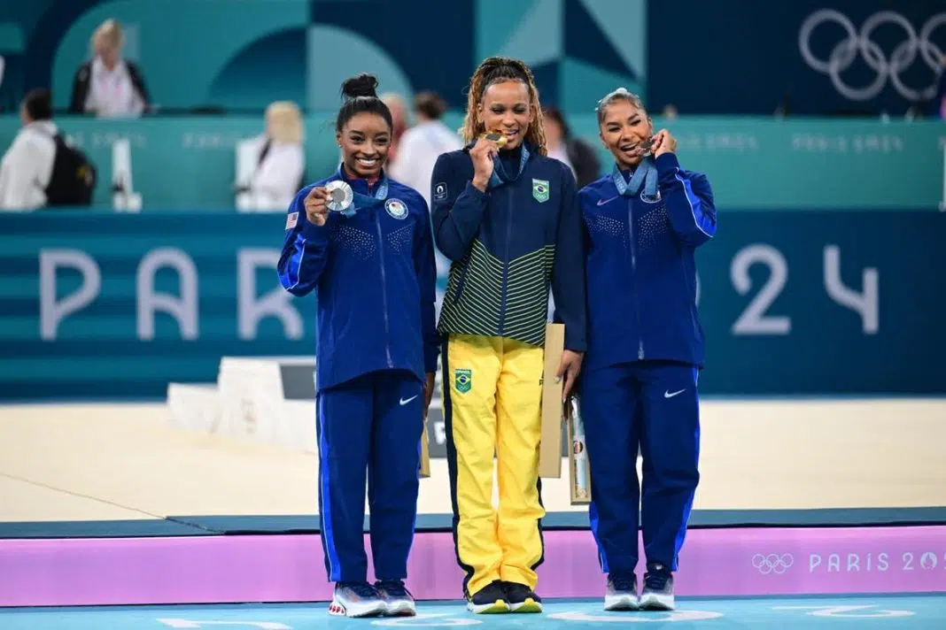 Medaliata cu aur Rebeca Andrade (centru) din echipa Braziliei, medaliata cu argint Simone Biles (stânga) din echipa Statelor Unite și medaliata cu bronz Jordan Chiles (dreapta) din echipa Statelor Unite sărbătoresc pe podium la ceremonia de decernare a medaliilor pentru exercițiul la sol feminin din cadrul competițiilor de gimnastică artistică, în a zecea zi a Jocurilor Olimpice de la Paris 2024, la Bercy Arena, pe 5 august 2024, în Paris, Franța.