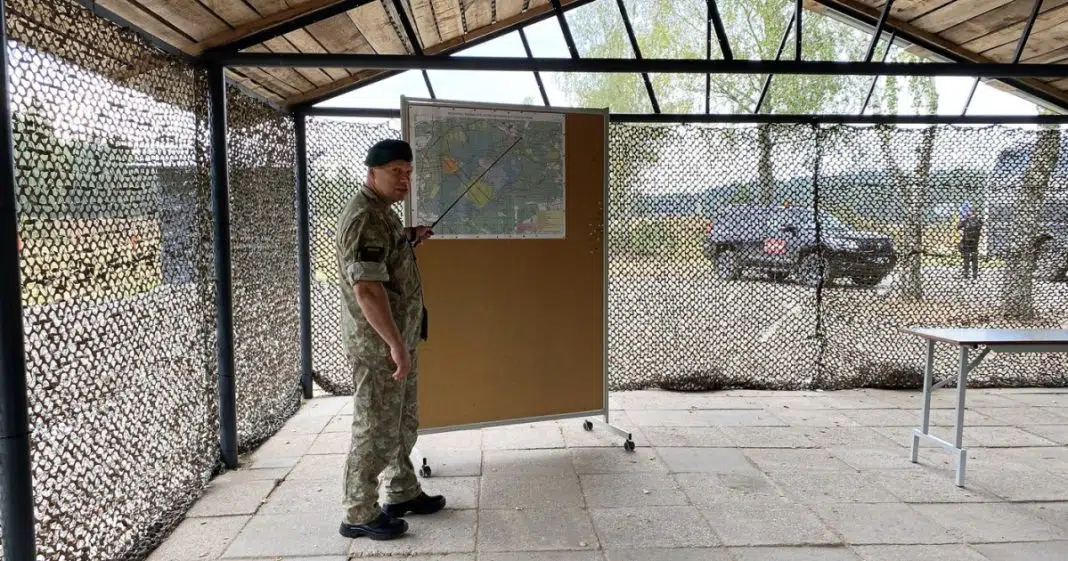 Soldat examinând harta la punct de control