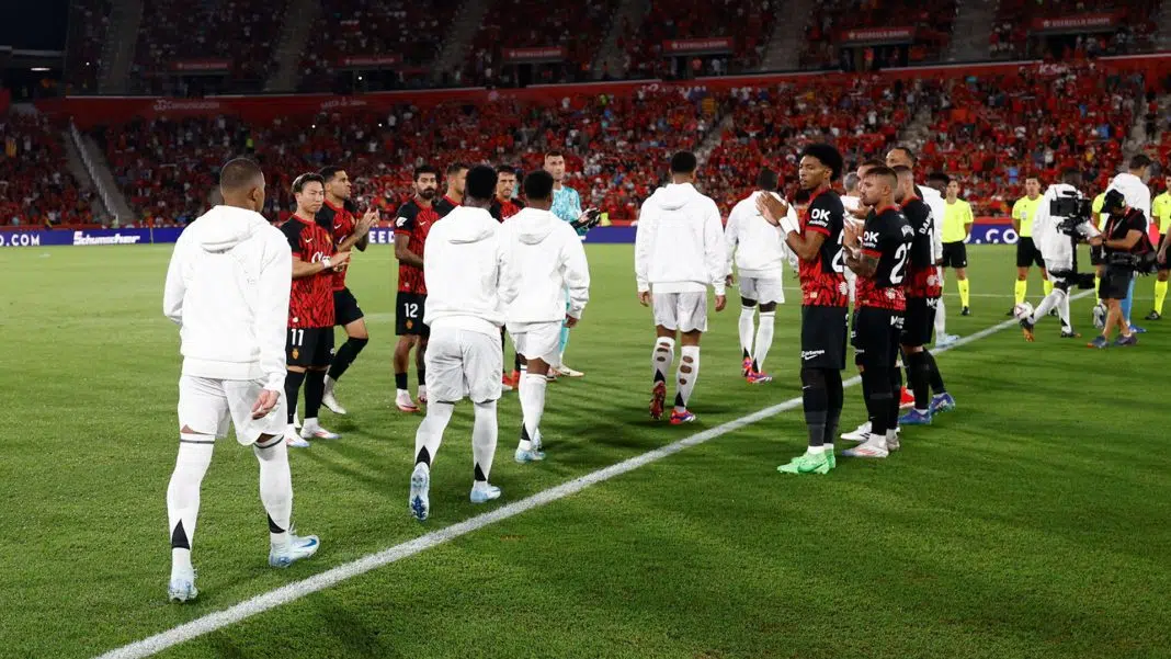 Fotbaliști salutându-se pe stadionul roșu plin. / mallorca real madrid