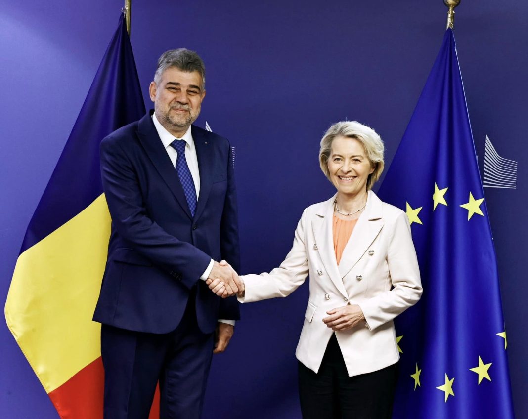 Oficiali zâmbitori strângând mâini, steaguri România și UE