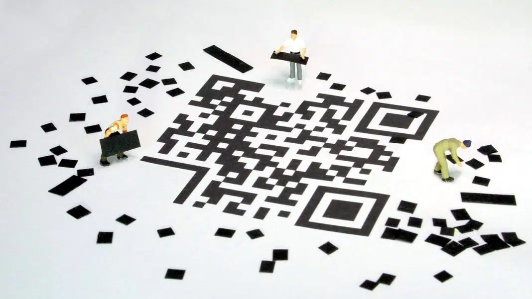 Figurine miniaturale pe un cod QR uriaș. / quishing cod qr phishing