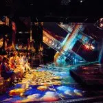 Spectacol teatru cu scenă inundată și public numeros