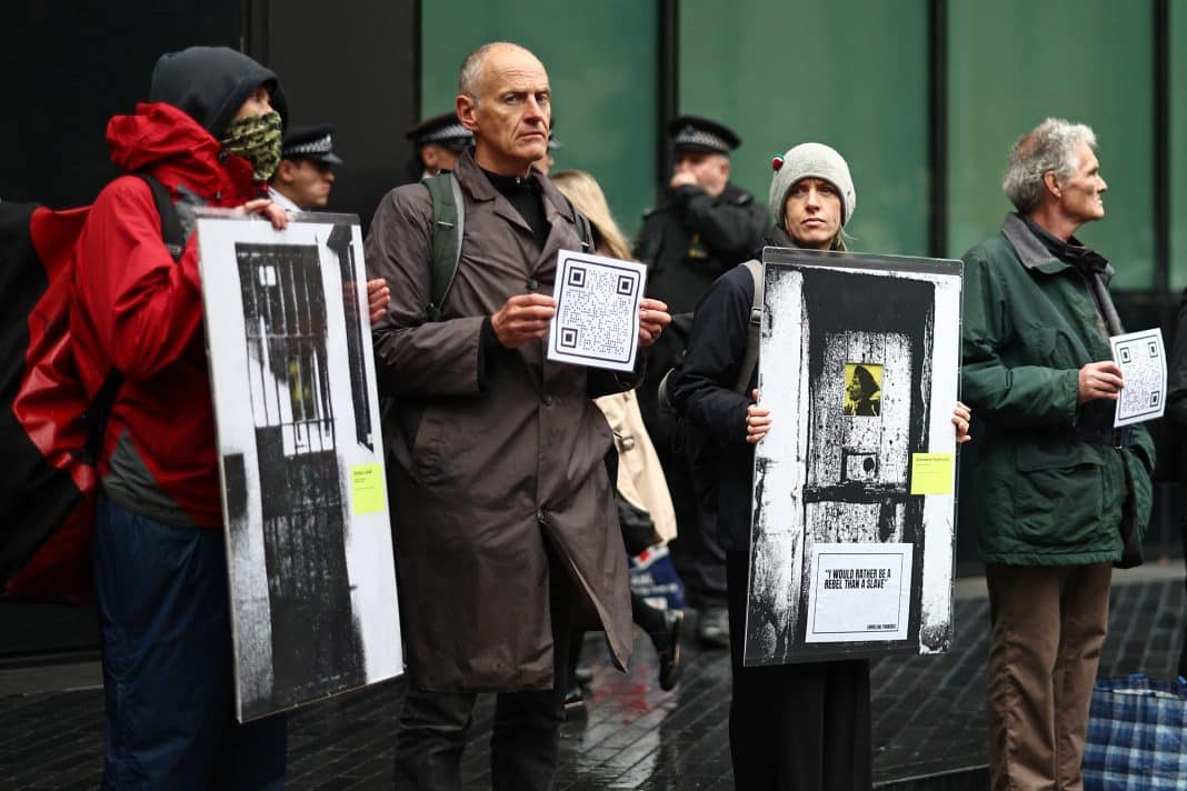 Protestatari ținând pancarte cu imagini și coduri QR