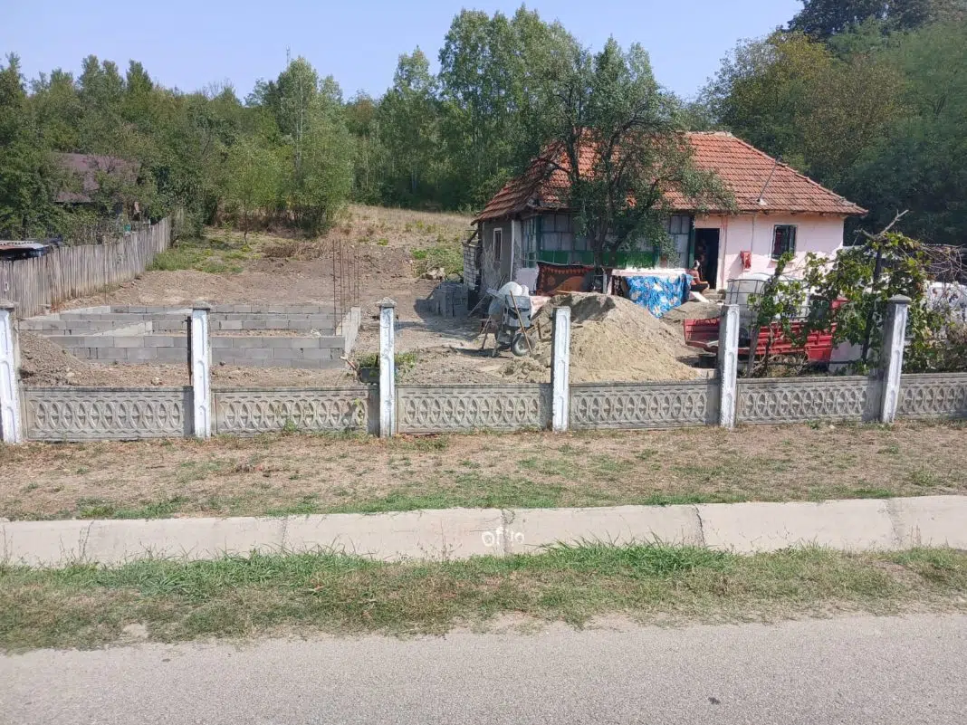 Casă rurală, fundație nouă, gard alb, România