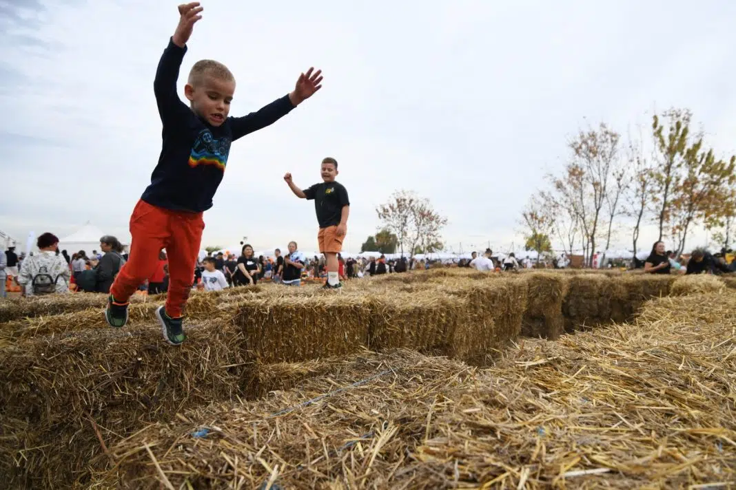 Copii jucându-se pe baloți de paie la festival