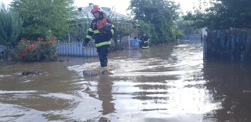 Pompieri ajutând oameni într-o inundație severă