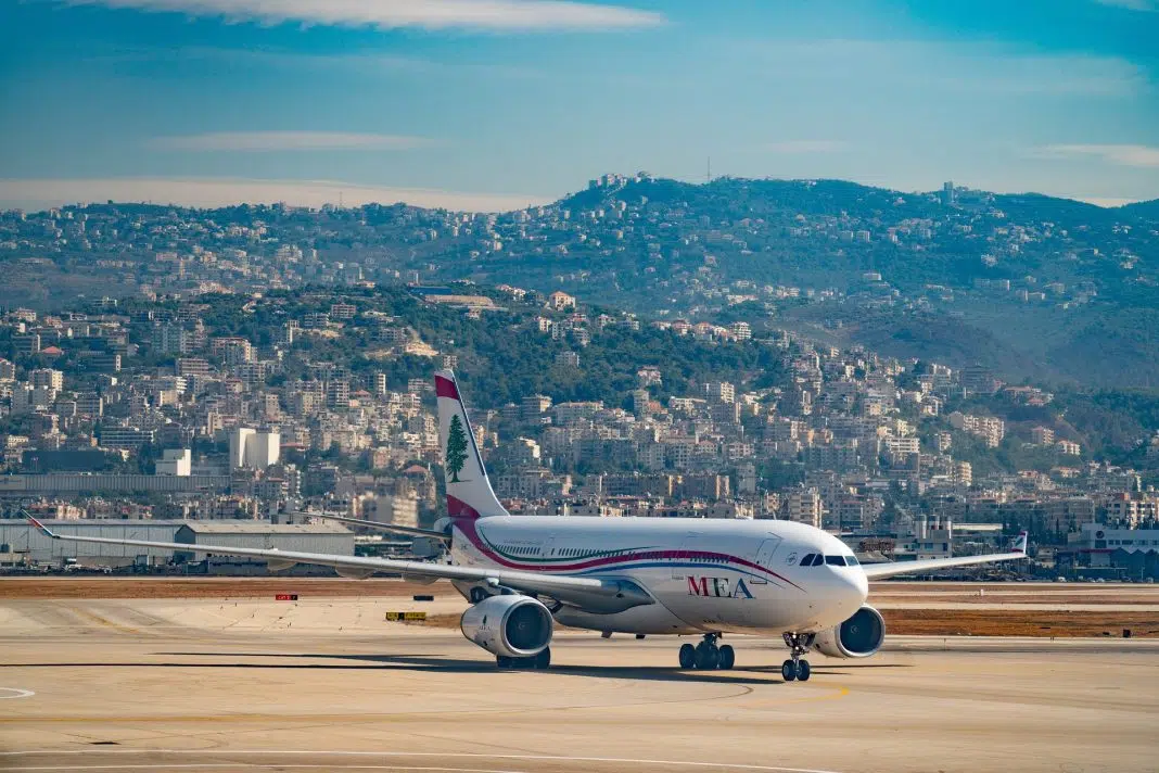 Avion MEA pe pistă, oraș în fundal