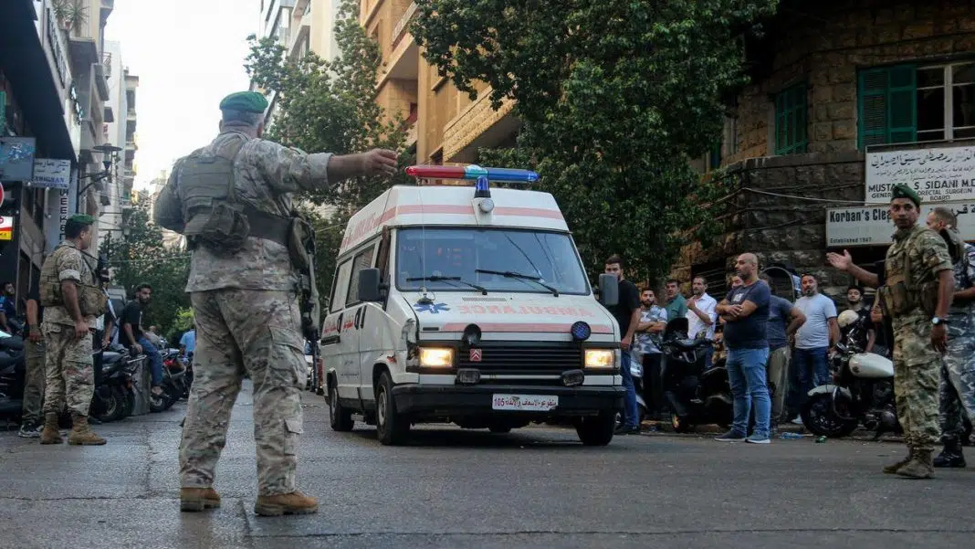 Ambulanță escortată de militari pe stradă aglomerată