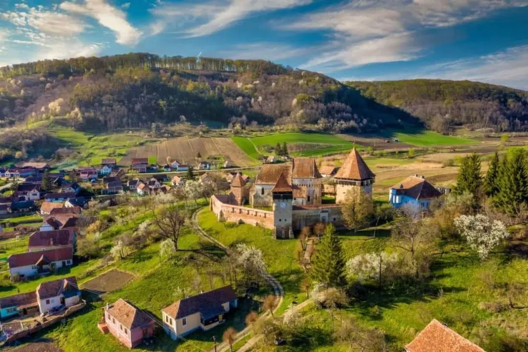 Cetatea medievală înconjurată de peisaj rural primăvaratic