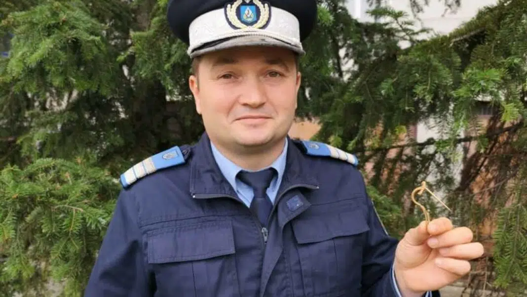 Polițist român ținând o cheie