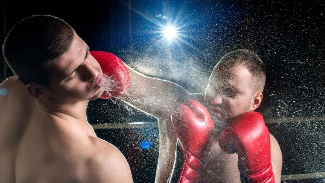 Boxeri combat în ring, lovitura puternică, stropi de sudoare