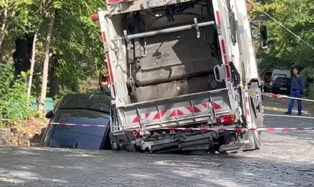 Mașină strivită sub camion de gunoi